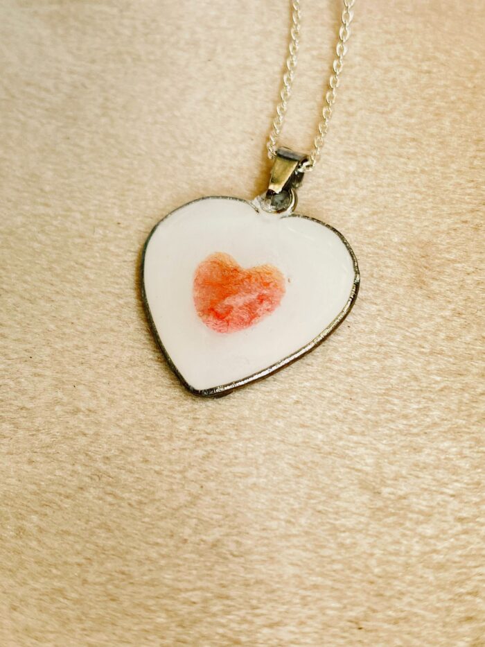 Muttermilchschmuck aus Edelstahl mit einer Blüte vom Brautstrauß in Herzform. Herzkette mit Muttermilch