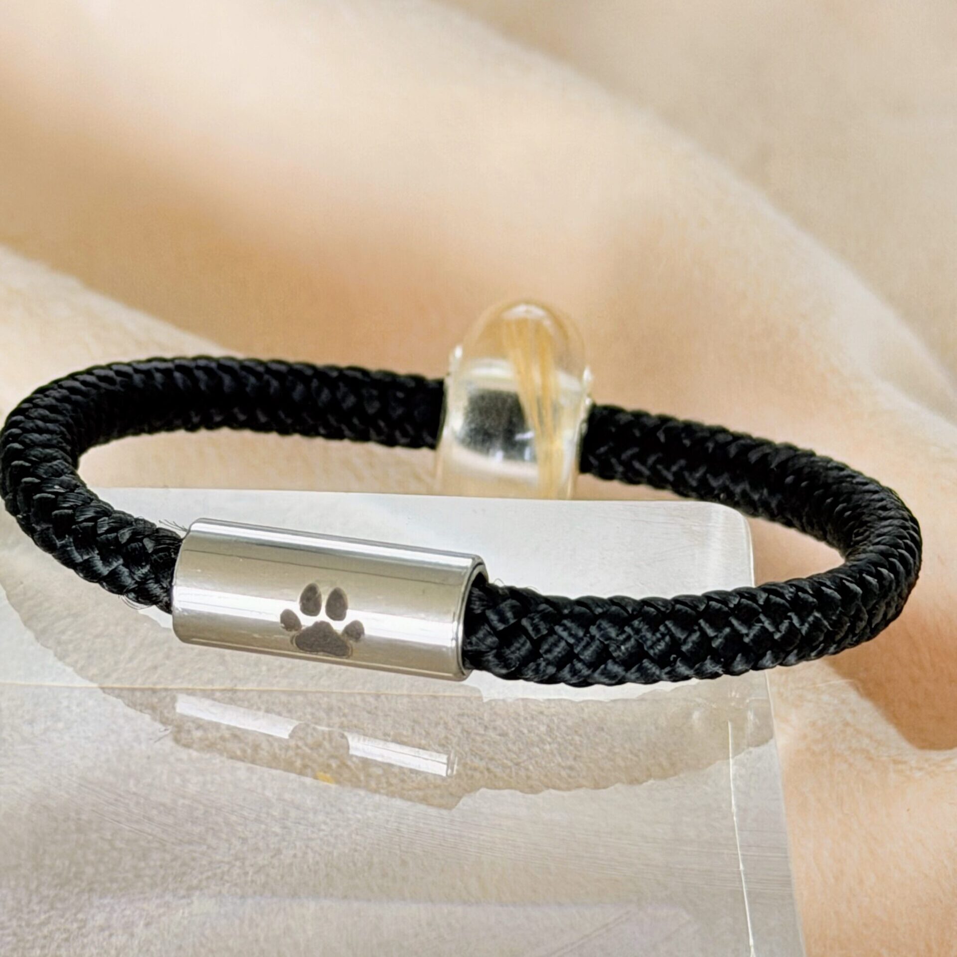 Nahaufnahme des Edelstahlverschlusses mit feiner Pfoten-Gravur am Segeltau Armband. Hochwertige Verarbeitung, personalisierbares Erinnerungsarmband.